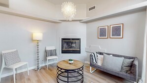 A modern living room with a round wooden table, white chairs, a grey sofa, a floor lamp, and two framed abstract artworks on the wall. - Bright 3bd/2.5b Home w/Garage, Dog, Firepit (Albuquerque)