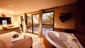 A bedroom with a large bed, a bathroom with a bathtub, and a sliding glass door leading to a balcony. - Nativos de Minas (Santana do Riacho)