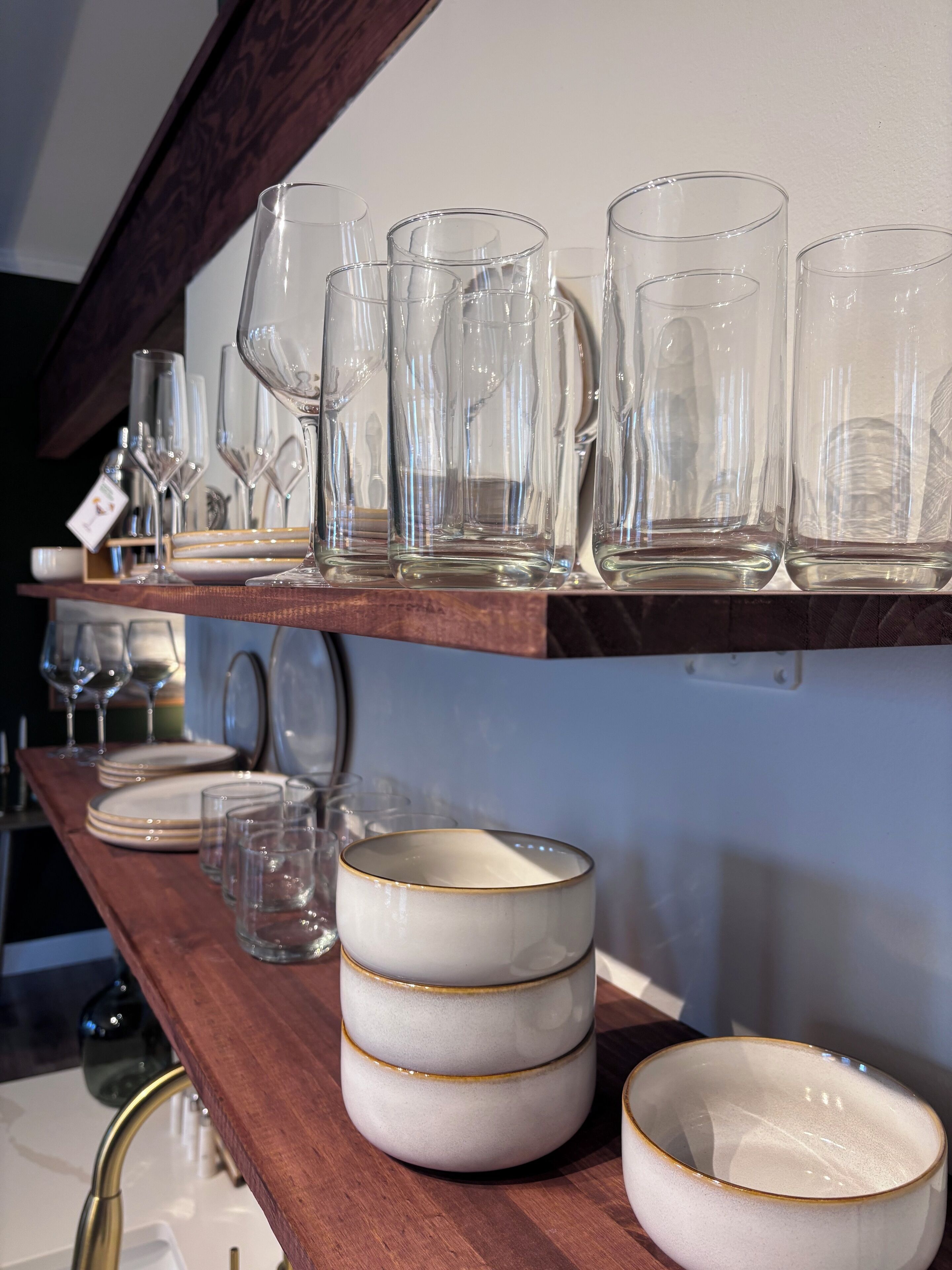 Une étagère contenant divers objets en verre et des plats en céramique.