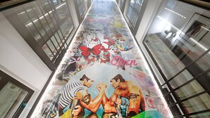 A corridor with a mural featuring cartoon characters and the word "Open".