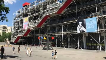Un bâtiment moderne, avec des échafaudages, une grande affiche de Walker Evans et une zone piétonne.