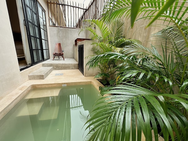 A small courtyard with a pool, steps leading to a door, and a chair. - Casa Kobaab Tulum (Tulum)