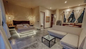 Ένα σύγχρονο δωμάτιο ξενοδοχείου με ένα κρεβάτι, έναν καναπέ και ένα μικρό τραπεζάκι.