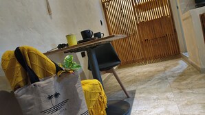 Una habitación con una mesa de comedor, sillas, un bolso amarillo y una puerta de madera.