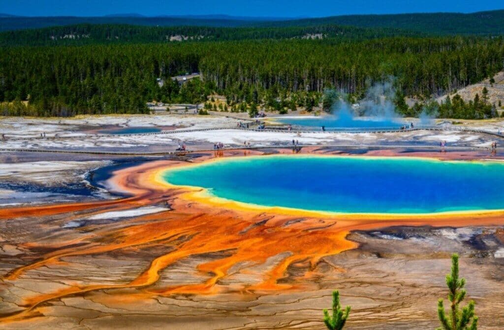 A geothermal area with a large pool of water and mineral deposits.