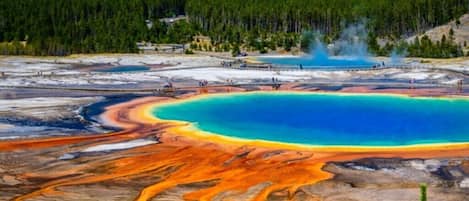 Un área geotérmica con una gran piscina de agua y depósitos minerales.
