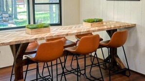 Ein Essbereich mit Holztisch, vier Stühlen und einem Gemälde an der Wand.