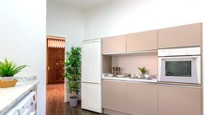 A modern kitchen with a built-in oven, a coffee maker, and a potted plant. - 3 Bd Apartment With Balconies Next to Larios Street Larios (Málaga)