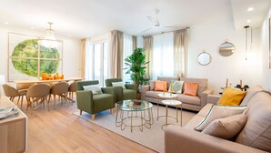 A modern living room with a sofa, chairs, a coffee table, and a dining area with a table and chairs. - Amazing Apartment 5 Bd in the Heart of Granada Alh Ndiga (Granada)