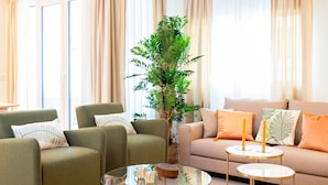 A living room with a sofa, two armchairs, a glass coffee table, and a potted plant. - Amazing Apartment 5 Bd in the Heart of Granada Alh Ndiga (Granada)