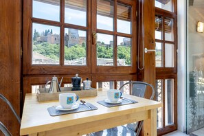 A wooden table with two white cups and saucers, a coffee pot, and a tray with utensils. - Amazing 3Bd Apartm in Albaicin With a Private Terrace and Views to the Alhambra Mirador de la Victoria (Granada)