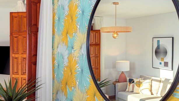 A living room with a round mirror, wooden doors, a sofa, a lamp, and a framed artwork. - Amazing 1-bedroom House in the Albaicin Mirador de San Cristobal (Granada)