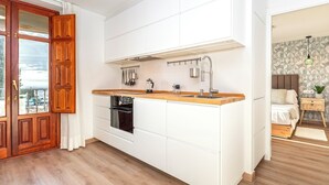 A modern kitchen with white cabinets, a wooden countertop, and a built-in oven. - Amazing 1-bedroom House in the Albaicin Mirador de San Cristobal (Granada)