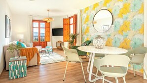 A modern living room with a sofa, a coffee table, and a dining area with chairs. - Amazing 1-bedroom House in the Albaicin Mirador de San Cristobal (Granada)