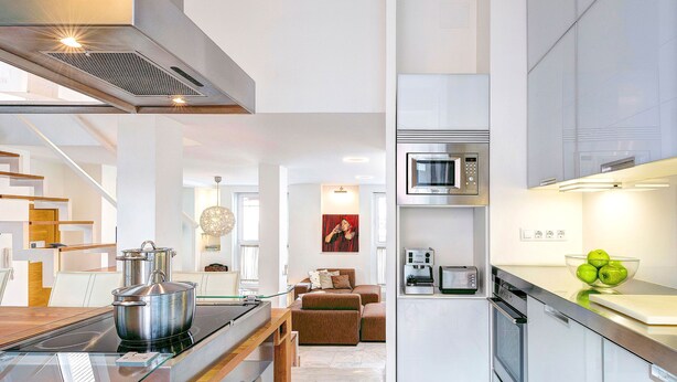 A modern kitchen with a stove, microwave, and a bowl of apples on the counter. - Amazing Duplex up to 4 Guest Private Terrace Real de La Carreteria (Seville)