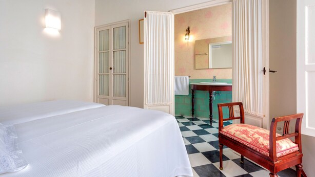 A room with a bed, a chair, a mirror, and a sink. - Beautiful 4 Bd House With Terrace Views to the Alcazar Gardens Casa Alcazar (Seville)