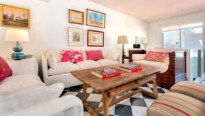 A living room with a checkered floor, a sofa, a coffee table, and framed pictures on the wall. - Beautiful 4 Bd House With Terrace Views to the Alcazar Gardens Casa Alcazar (Seville)