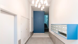 A hallway with a blue wall, a staircase, and a row of mailboxes. - Beautiful 1 bd Apartment in the Historic Center of Cadiz Sagasta (Cádiz)