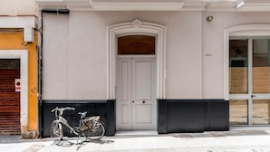 A building facade with a white door, a bicycle parked outside, and a balcony with white railings. - Beautiful 1 bd Apartment in the Historic Center of Cadiz Sagasta (Cádiz)