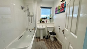 Een haardroger, handdoeken, zeep, toiletpapier