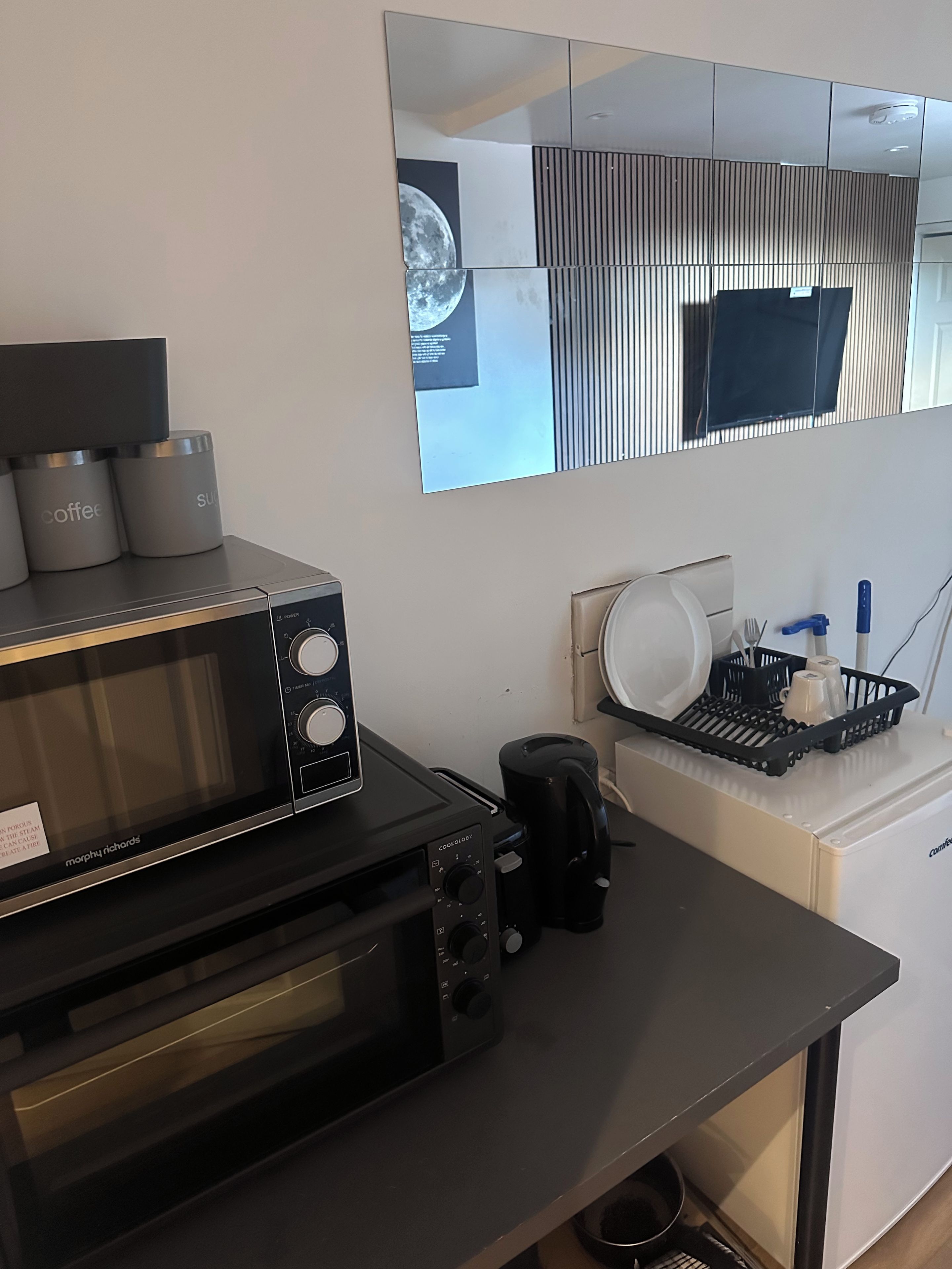 A kitchenette with a microwave, toaster, and coffee maker.