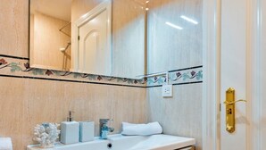 A bathroom with a wooden vanity, a white sink, and a mirror above it. - Cozy Bright Apartment in the Center of Granada Reyes Cat Licos (Granada)