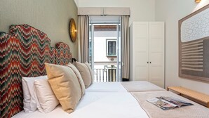 A hotel room with a bed, a bench, a wardrobe, and a view of the outside balcony. - Cozy 2 Bedrooms Apartment in the City Center Zaragoza I (Seville)