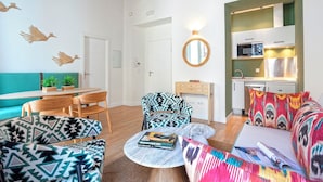 A modern living room with a sofa, chairs, a coffee table, and a kitchen area with a microwave and cabinets. - Cozy 2 Bedrooms Apartment in the City Center Zaragoza I (Seville)