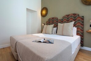 A neatly made bed with a patterned bedspread and pillows, a magazine on the bed, and a decorative wall hanging above the bed. - Cozy 2 Bedrooms Apartment in the City Center Zaragoza I (Seville)