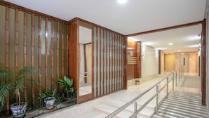 A hotel lobby with a wooden partition, potted plants, a staircase, and a reception desk. - Cozy Apartment Near City Center Lope de Vega (Granada)