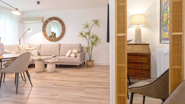 A modern living room with a sofa, coffee table, and chairs. There is a lamp, a mirror, and a plant. - Cozy Apartment Near City Center Lope de Vega (Granada)