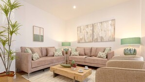 A living room with two sofas, a coffee table, and a potted plant. - Exclusive Apartment in City Center Capiteles (Granada)