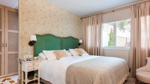 A bedroom with a green headboard, white bedding, a nightstand with a lamp, and a window with curtains. - Fantastic 3 Bd 3 Bth Apartm With Comunnal Terrace Carmen San Ignacio II (Granada)