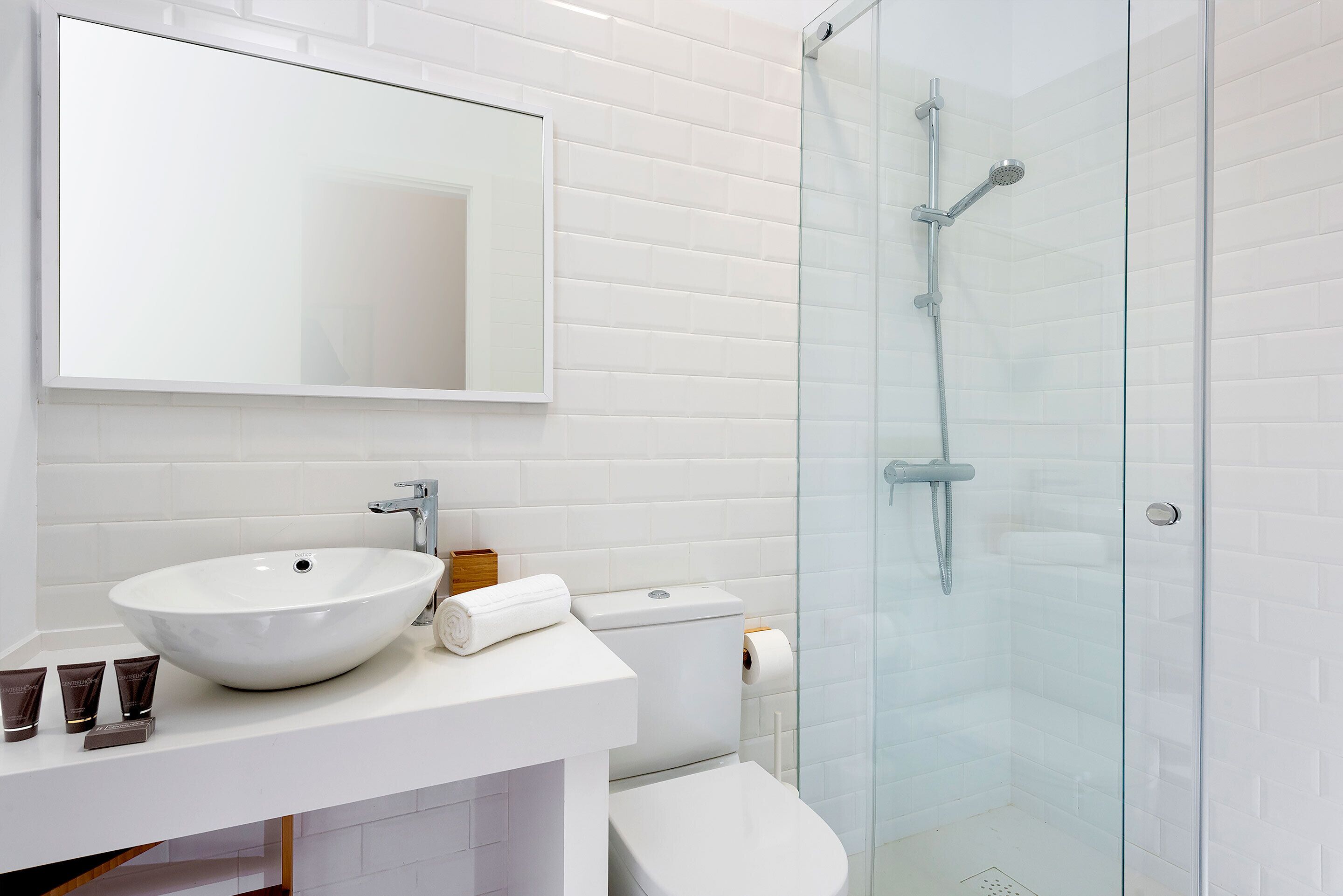 Ein modernes Badezimmer mit Waschbecken, Spiegel und Duschkabine aus Glas.