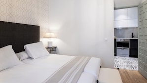 Une chambre d’hôtel avec un lit, une table de chevet, une lampe et une vue sur la cuisine.