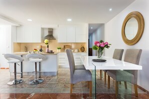 A modern kitchen with white cabinets, a central island, and bar stools. - Great Penthouse in Prime Location 4 Bb With Terrace Gran Capitan (Granada)