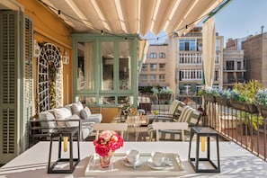 An outdoor seating area with a table, chairs, and a view of the cityscape.