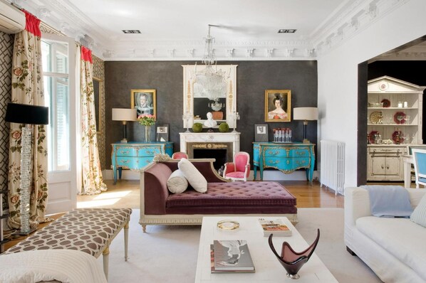 A spacious living room with a fireplace, two side tables, a sofa, and a coffee table.