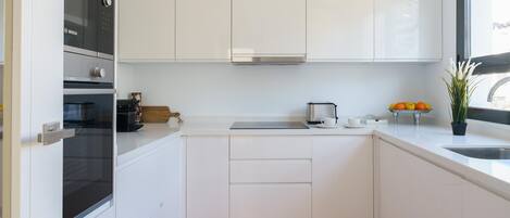 Eine moderne Küche mit weißen Schränken, einem Bosch-Ofen, einem Toaster und einer Spüle.