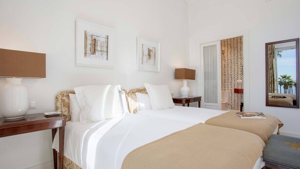 A hotel room with a large bed, two bedside tables, a mirror, and artwork on the walls. - Luxury Apartment in Malaga Beach Paseo Mar Timo (Málaga)
