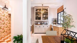 Una cocina moderna con armarios blancos, una mesa de comedor de madera y un salpicadero decorativo.
