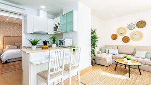 A compact living space with a kitchenette, a dining area, a sofa, and a coffee table. - Magnificent Penthouse in the Center of Malaga Marin Garcia V (Málaga)