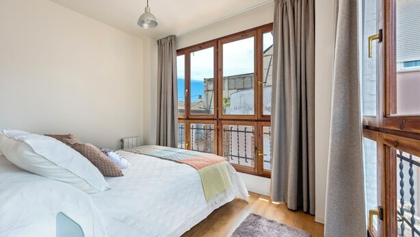 A bedroom with a bed, a window, and a view of the outside. - Modern Confortable 3 Bd Duplex Great Location Piedra Santa (Granada)