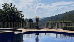 A swimming pool with a clear view of the surrounding landscape, including trees and a distant mountain range. - Beautiful Mairiporã Farm with Beach Tennis Court (Mairiporã)