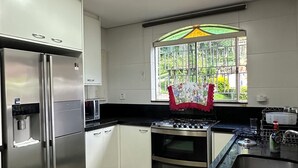 A modern kitchen with stainless steel appliances, a gas stove, and a built-in oven. - Beautiful Mairiporã Farm with Beach Tennis Court (Mairiporã)