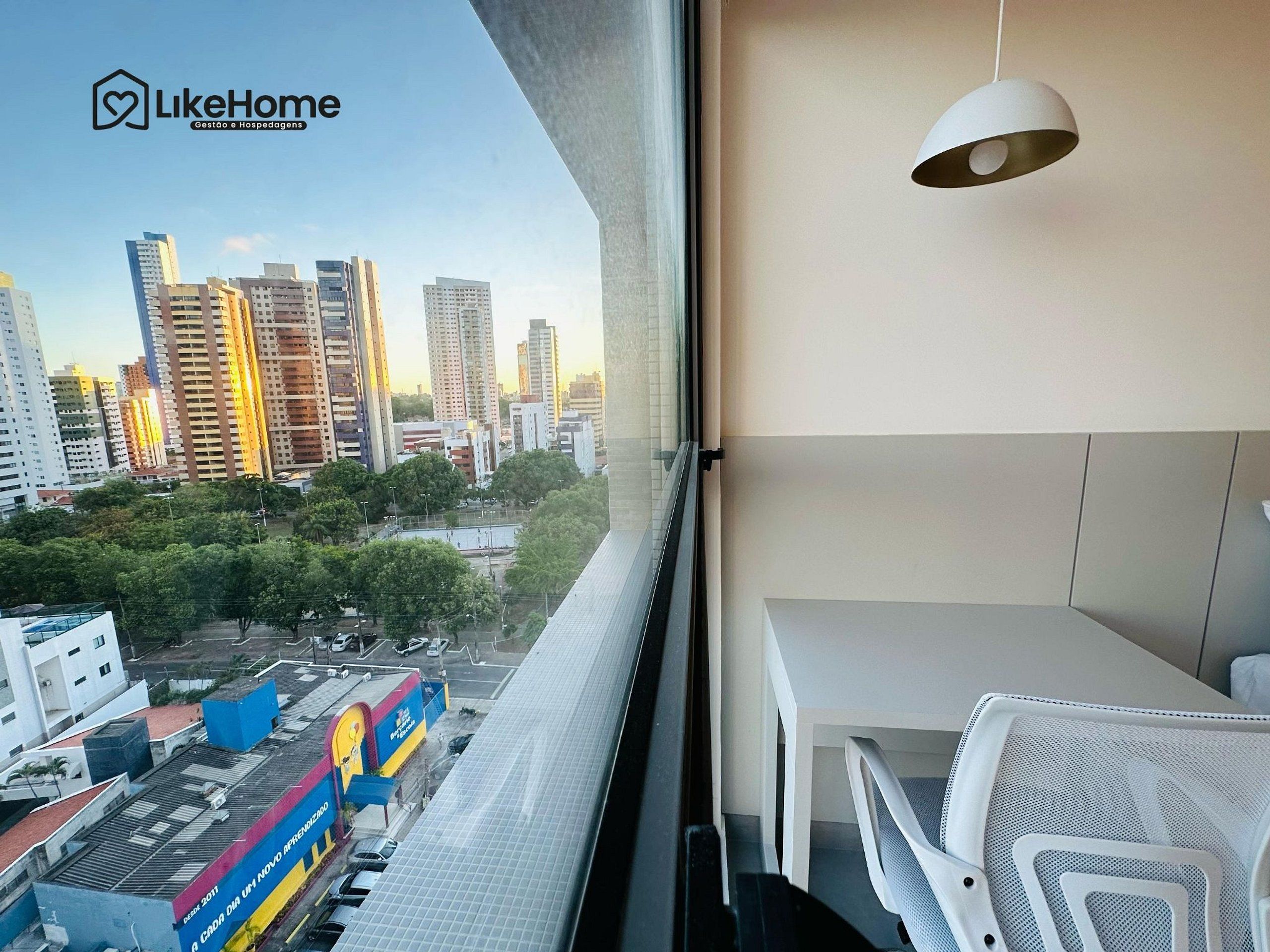 Un edificio de gran altura con vistas a un paisaje urbano, que incluye un autobús y un estacionamiento.