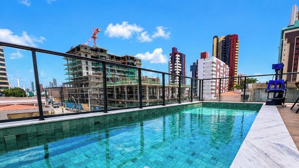 A rooftop pool with a view of a cityscape, including a construction site and high-rise buildings. - Simple Smart - LikeHome Hospedagens (João Pessoa)