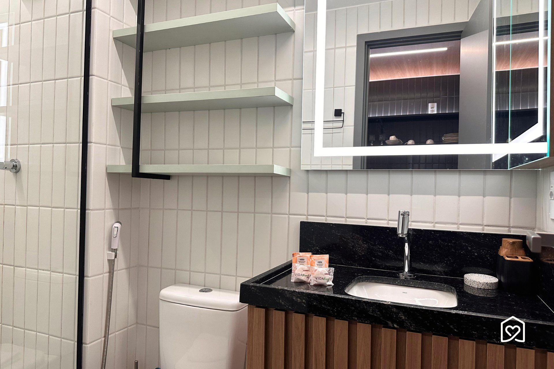 A modern bathroom with a toilet, a sink, and a mirror.