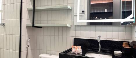 A modern bathroom with a toilet, a sink, and a mirror.