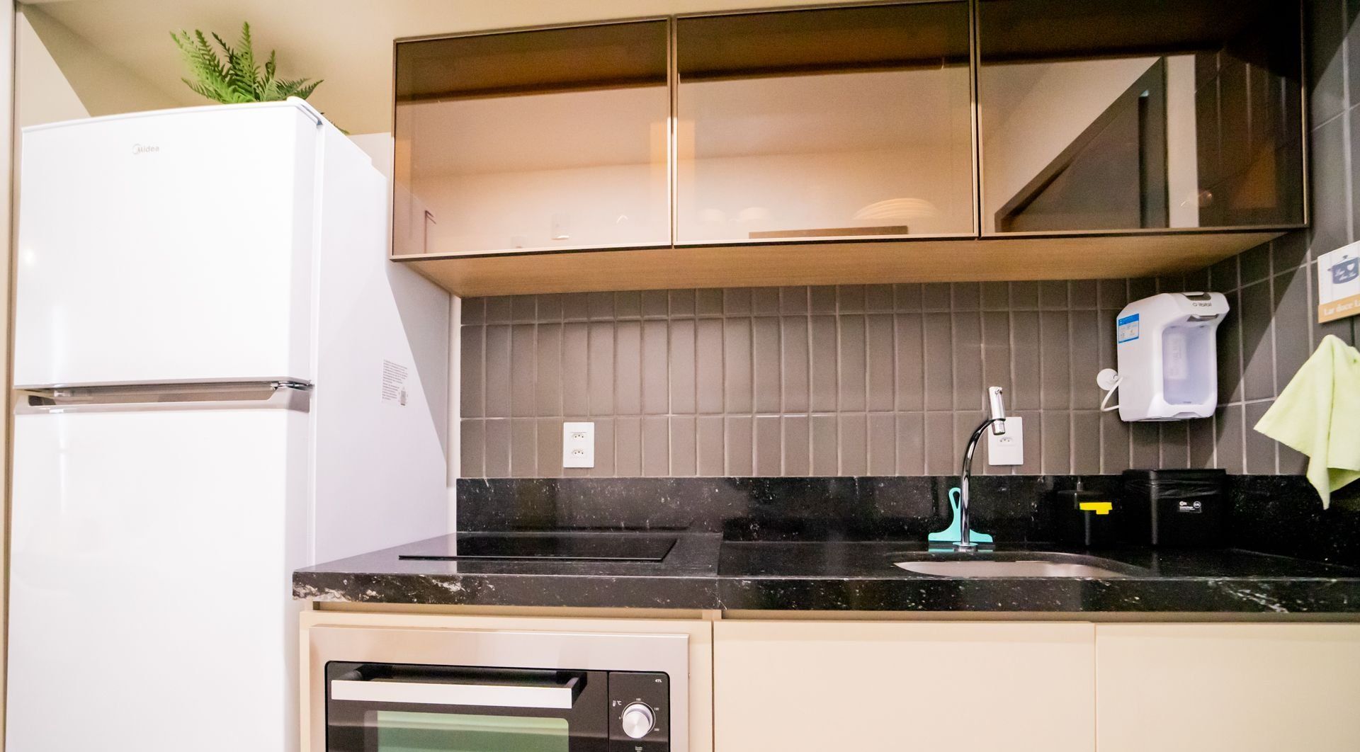 A kitchen with a white refrigerator, a dishwasher, a sink with a faucet, and a tiled backsplash.